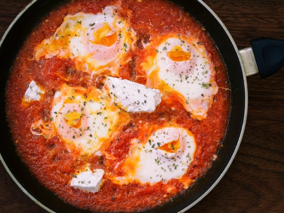 Eggs poached in spiced tomato sauce in a skillet